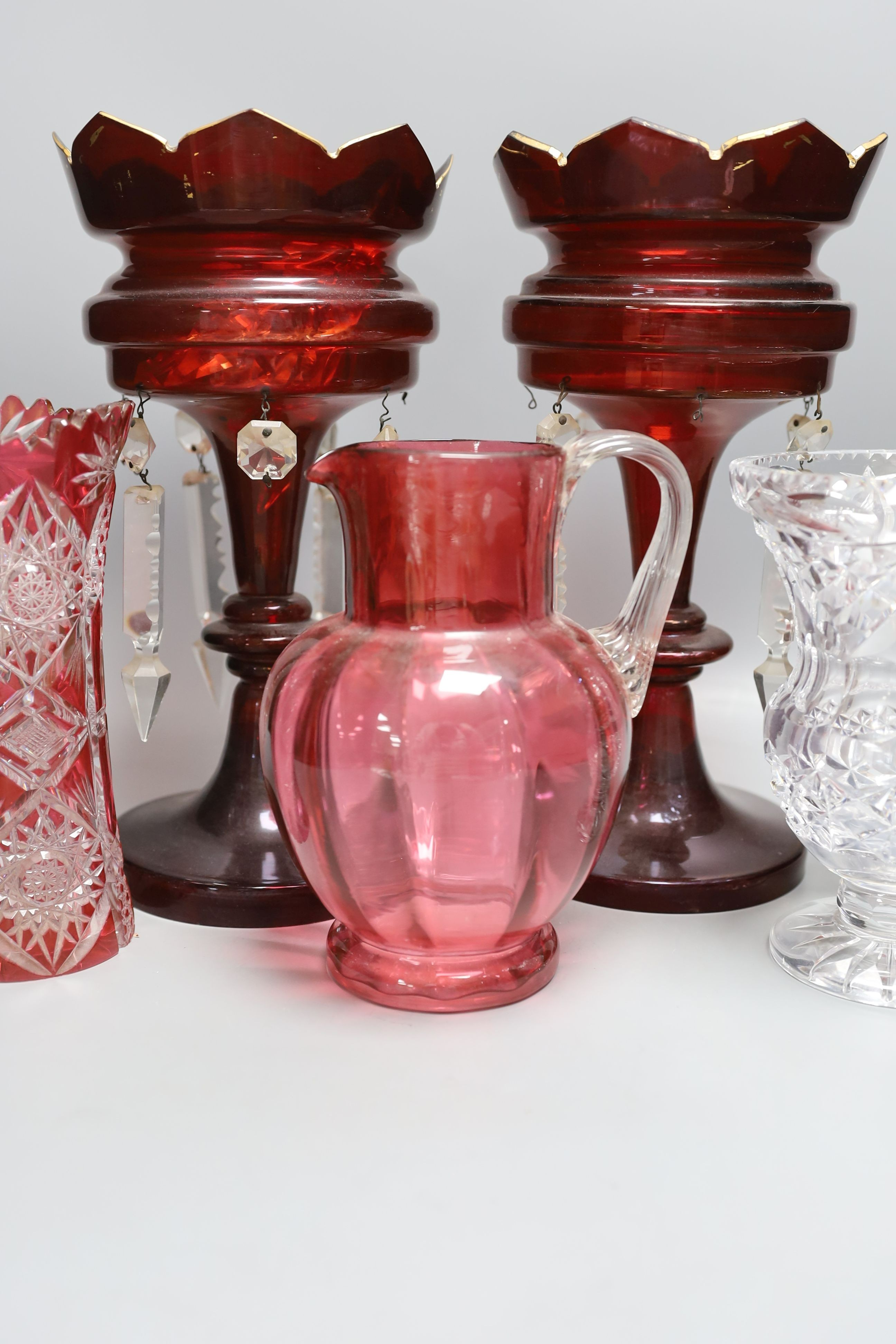 A pair of late 19th century ruby glass lustres, 30cm tall, cranberry jug, Bohemian vase and one other (5)